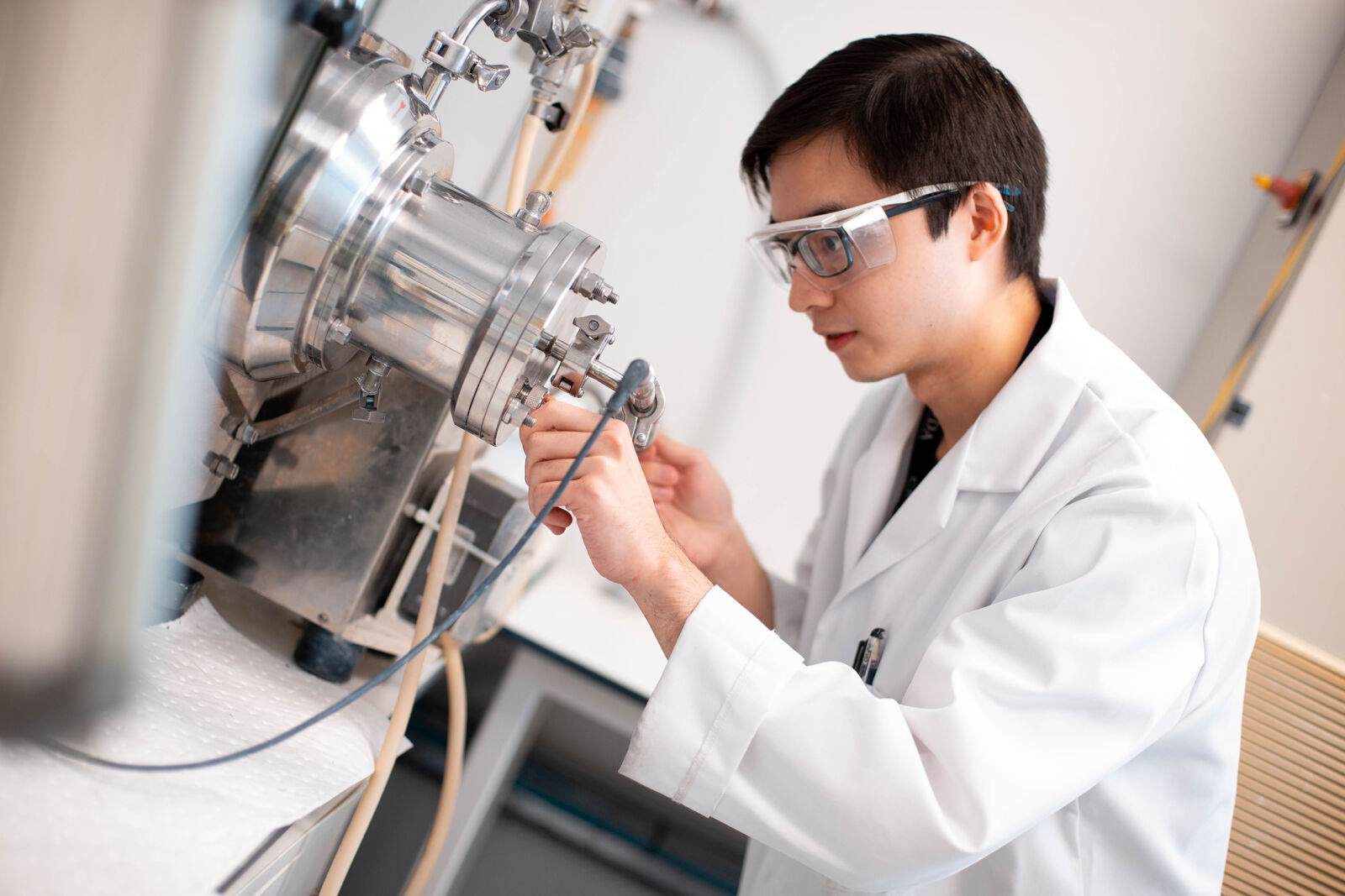 male scientist working in laboratory wearing protective clothing