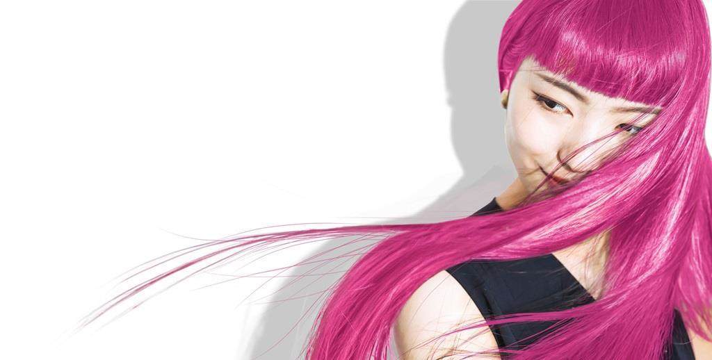 Model with vibrant pink hair flowing across the image, showcasing bold hair colour and shine for beauty and hair care innovation