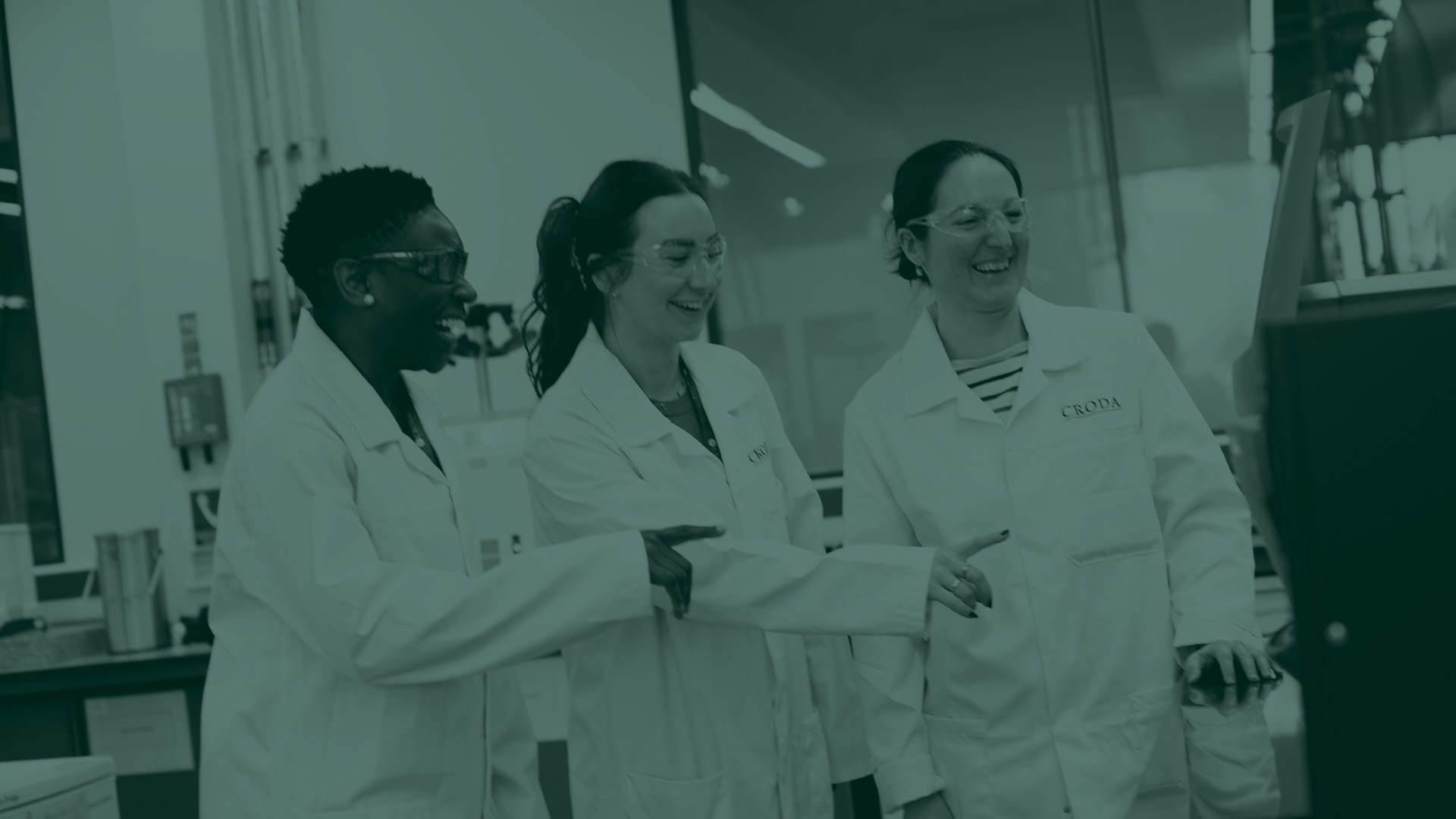 Green tone image of three female scientists in a laboratory