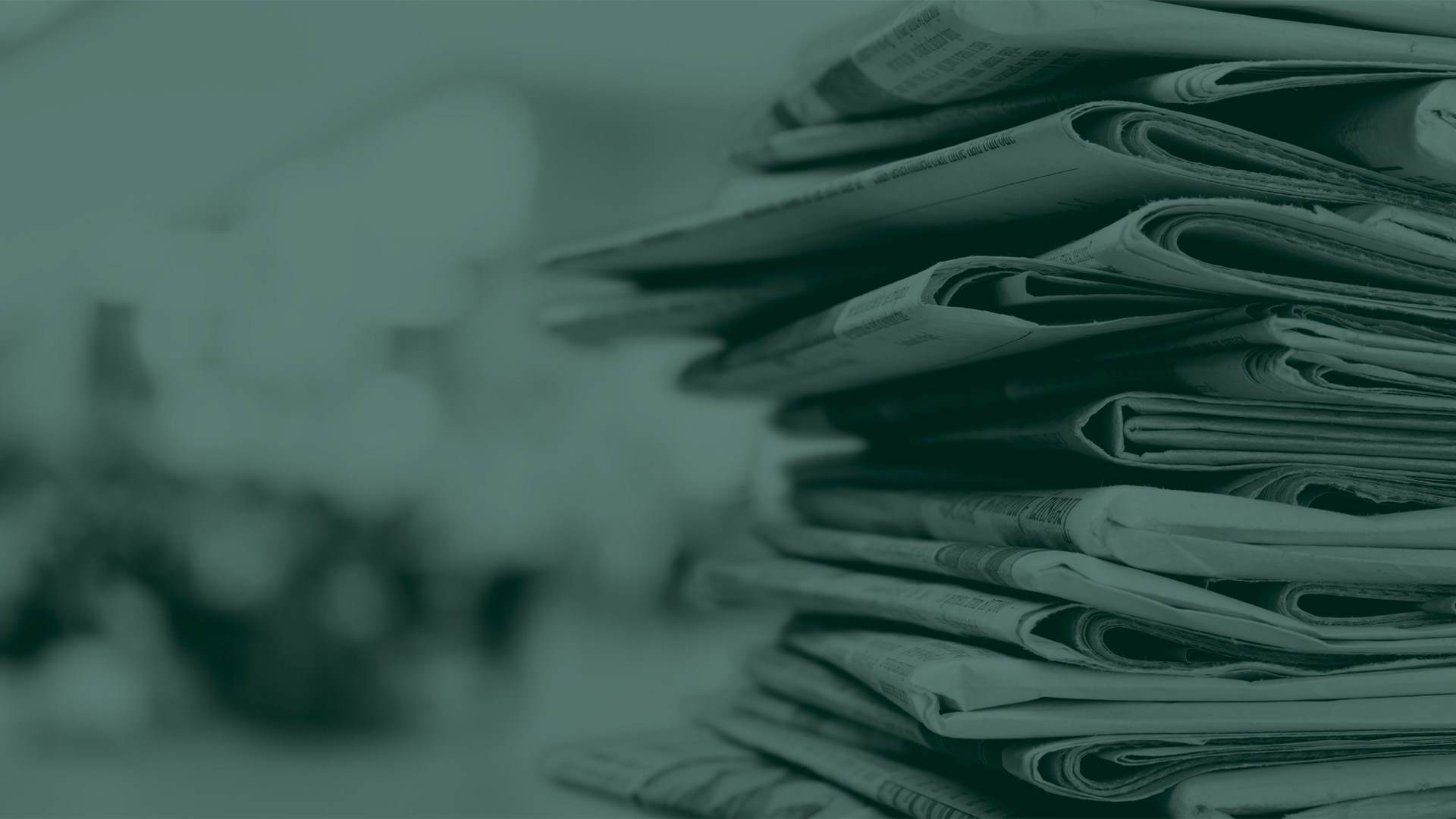 Green tone image of a stack of newspapers