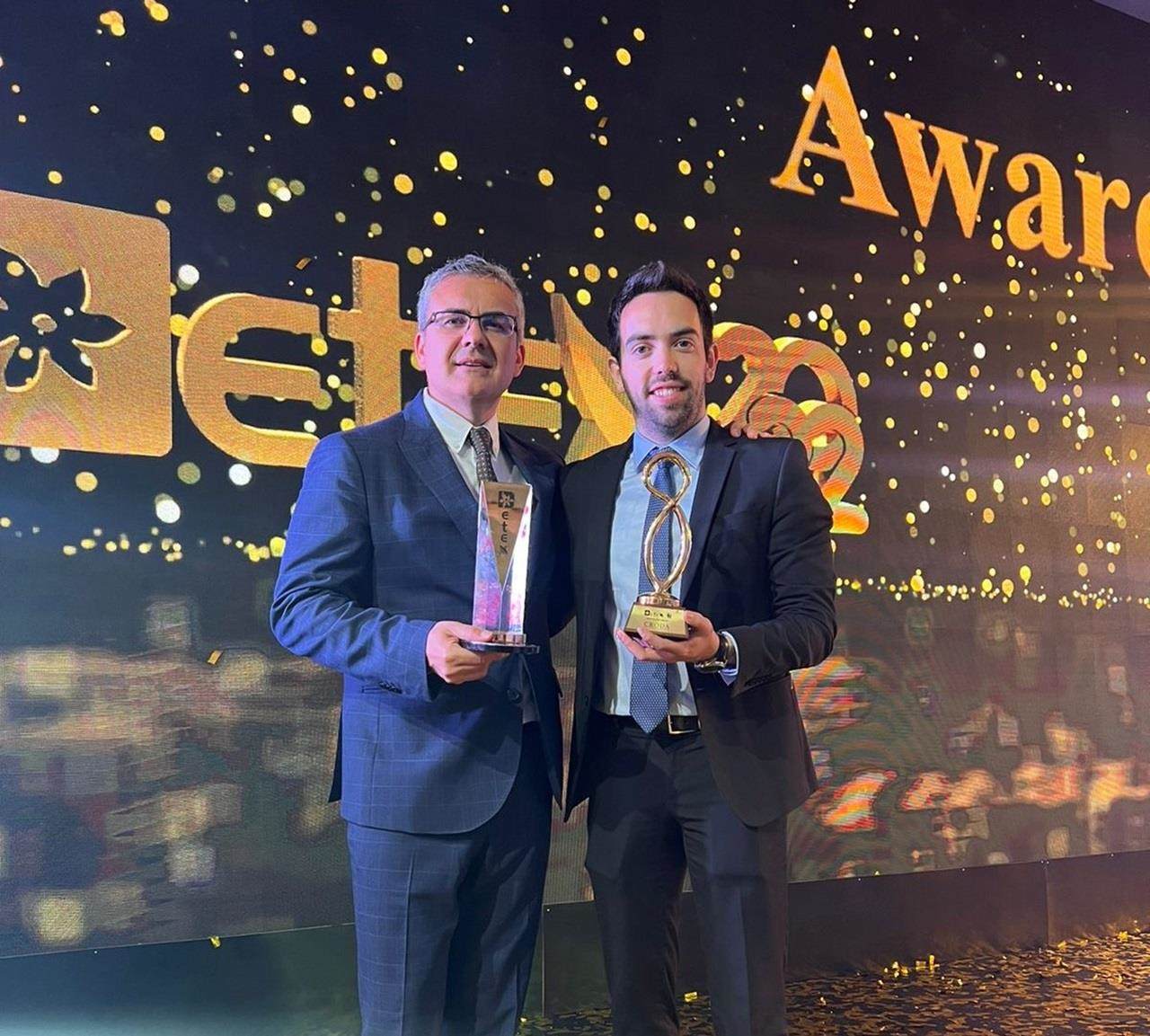 two male employees receiving award