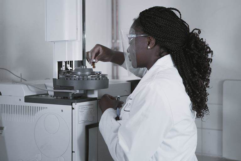 girl in laboratory performing experiment under microscope