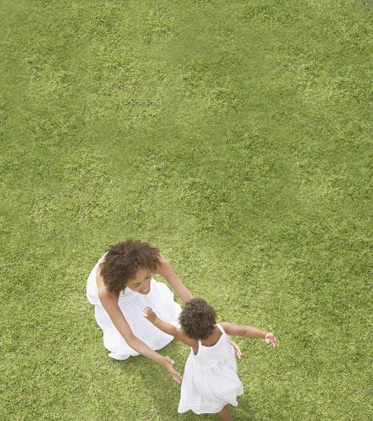 mum and daughter sat on grass together