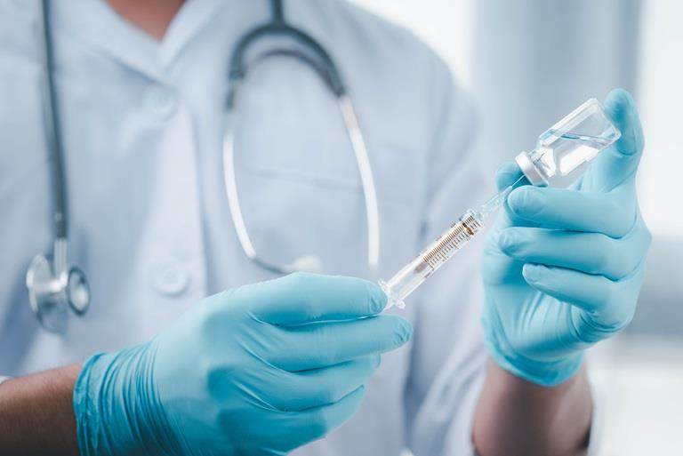 scientist wearing gloves showing vaccine