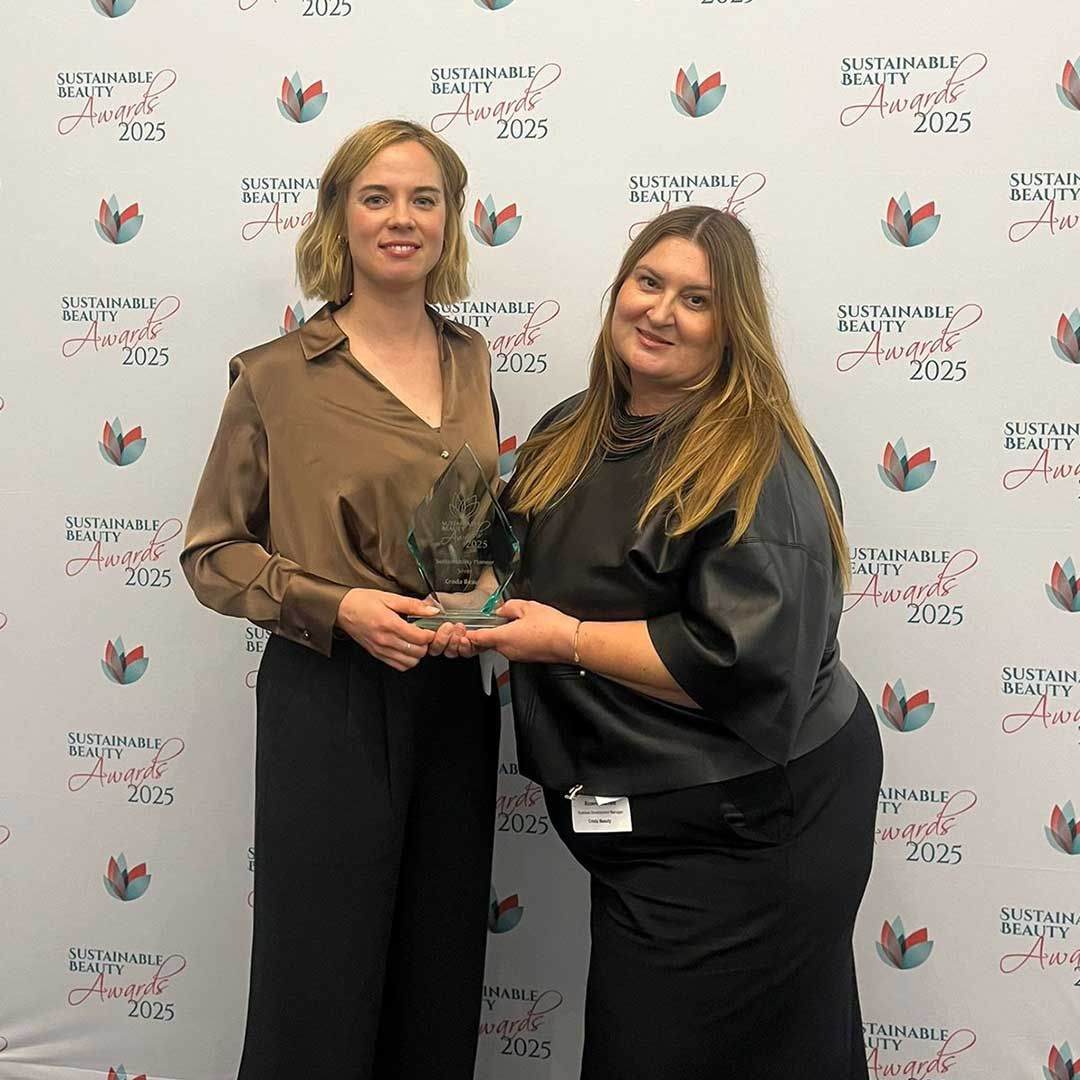 two employees holding award